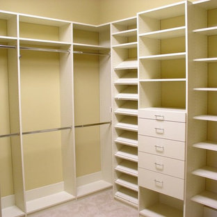 Inredning av ett klassiskt mellanstort walk-in-closet för könsneutrala, med öppna hyllor, vita skåp, heltäckningsmatta och beiget golv