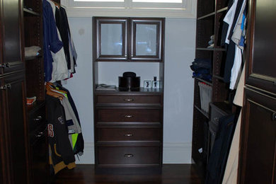 Closet - gender-neutral closet idea in Chicago with dark wood cabinets