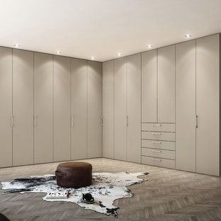 Imagen de vestidor unisex, contemporáneo, extra grande, con armarios con paneles lisos, puertas de armario beige y suelo de madera oscura