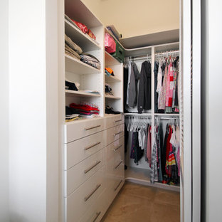 Cette photo montre un petit dressing tendance neutre avec un placard à porte plane, des portes de placard blanches, un sol en carrelage de porcelaine et un sol beige.