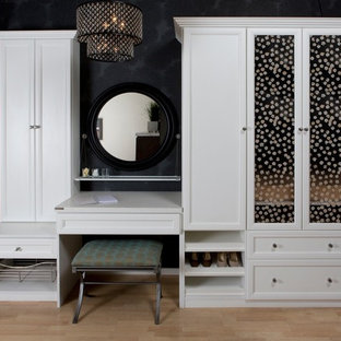 Mid-sized trendy women's light wood floor walk-in closet photo in Santa Barbara with white cabinets