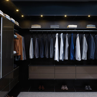 Idéer för att renovera ett stort funkis walk-in-closet för män, med öppna hyllor, svarta skåp och heltäckningsmatta