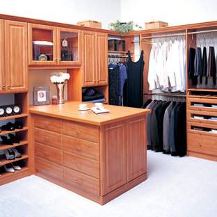 Diseño de armario vestidor unisex, tradicional, grande, con armarios con paneles con relieve, puertas de armario de madera oscura, suelo de cemento y suelo blanco