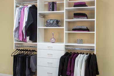 Foto de armario unisex de tamaño medio con armarios con paneles lisos, puertas de armario blancas, suelo de madera en tonos medios y suelo marrón
