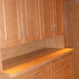 Diseño de armario vestidor unisex, actual, de tamaño medio, con armarios con paneles con relieve, puertas de armario de madera clara, moqueta y suelo beige