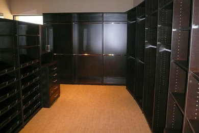 Inspiration for a mid-sized contemporary gender-neutral carpeted and beige floor walk-in closet remodel in Other with flat-panel cabinets and dark wood cabinets