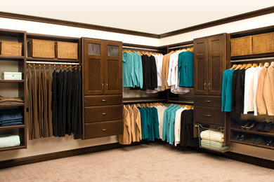 Modelo de armario vestidor unisex tradicional grande con armarios con paneles empotrados, puertas de armario de madera oscura, moqueta y suelo beige