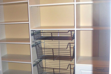 Example of a large classic gender-neutral carpeted walk-in closet design in DC Metro with raised-panel cabinets and white cabinets