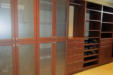 Imagen de vestidor unisex grande con puertas de armario de madera en tonos medios y suelo de madera clara