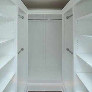 Inspiration pour un dressing room traditionnel de taille moyenne et neutre avec un placard avec porte à panneau surélevé, des portes de placard blanches et un sol en bois foncé.