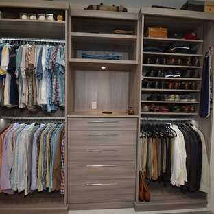 Example of a mid-sized trendy men's dressing room design in Tampa with flat-panel cabinets and medium tone wood cabinets