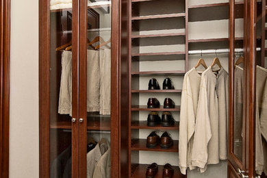 Modelo de armario vestidor unisex clásico grande con armarios con paneles con relieve, puertas de armario de madera oscura, moqueta y suelo marrón
