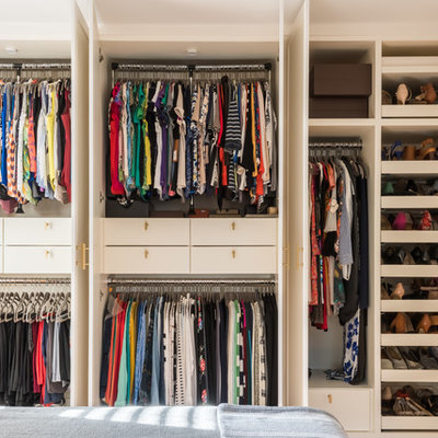 Inspiration for a mid-sized contemporary gender-neutral reach-in closet remodel in Houston with flat-panel cabinets and white cabinets