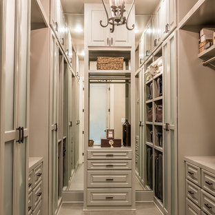 Immagine di un'ampia cabina armadio unisex chic con ante con bugna sagomata, ante marroni, pavimento in gres porcellanato e pavimento marrone