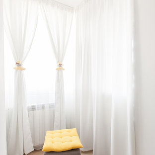 Immagine di un piccolo spazio per vestirsi unisex minimal con nessun'anta, ante bianche e pavimento in compensato