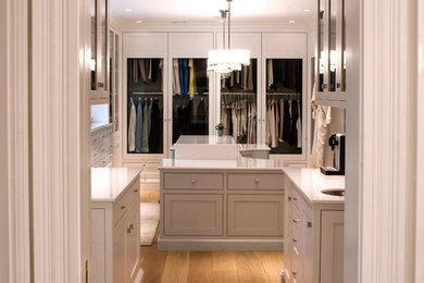 Modelo de vestidor clásico renovado grande con armarios estilo shaker, puertas de armario beige y suelo laminado