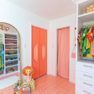Exemple d'un grand dressing tendance pour une femme avec des portes de placard blanches, un sol en carrelage de céramique, un sol rose et un placard à porte plane.