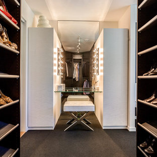 Immagine di armadi e cabine armadio unisex minimal con ante in legno bruno, moquette e pavimento nero