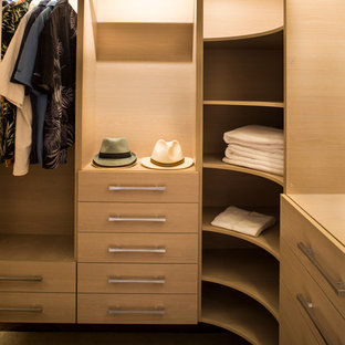 Immagine di una piccola cabina armadio unisex contemporanea con ante lisce, ante in legno chiaro e moquette
