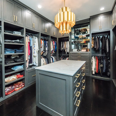 Inspiration for a large transitional gender-neutral dark wood floor and brown floor walk-in closet remodel in Dallas with gray cabinets and shaker cabinets