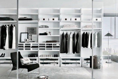 Diseño de armario vestidor unisex actual grande con armarios abiertos, puertas de armario blancas y suelo gris