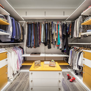 Idéer för att renovera ett stort funkis walk-in-closet för könsneutrala, med släta luckor, vita skåp och mellanmörkt trägolv