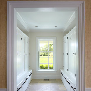 Inspiration pour un grand dressing marin neutre avec un placard avec porte à panneau encastré, des portes de placard blanches et un sol en calcaire.