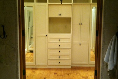 Imagen de armario vestidor unisex mediterráneo grande con armarios estilo shaker, puertas de armario blancas y suelo de madera en tonos medios