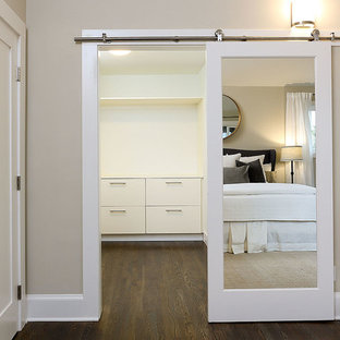 Immagine di una cabina armadio unisex classica di medie dimensioni con ante lisce, ante bianche, parquet scuro e pavimento marrone