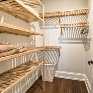 Foto di una cabina armadio unisex costiera di medie dimensioni con pavimento in legno massello medio e ante in legno chiaro