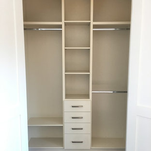 Imagen de armario vestidor unisex, tradicional renovado, grande, con armarios con paneles lisos, puertas de armario beige, suelo de madera oscura y suelo marrón