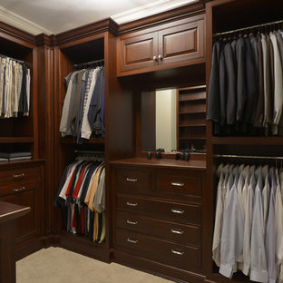Ejemplo de armario vestidor de hombre, clásico, de tamaño medio, con armarios con paneles con relieve, puertas de armario de madera en tonos medios, moqueta y suelo beige