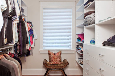 Mid-sized elegant gender-neutral medium tone wood floor and brown floor walk-in closet photo in Other with flat-panel cabinets and white cabinets