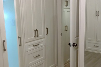 Huge elegant gender-neutral walk-in closet photo in Houston with shaker cabinets and white cabinets