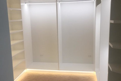 Foto de armario vestidor de mujer actual de tamaño medio con armarios abiertos, puertas de armario blancas, moqueta y suelo beige