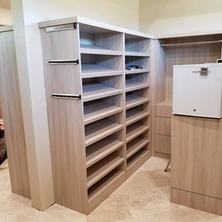 Diseño de vestidor de hombre, minimalista, grande, con armarios con paneles lisos, puertas de armario beige, suelo de travertino y suelo beige