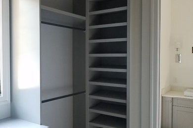 Walk-in closet - mid-sized contemporary gender-neutral walk-in closet idea in Raleigh with flat-panel cabinets
