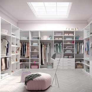 Diseño de armario vestidor unisex, moderno, grande, con armarios abiertos, puertas de armario blancas, suelo de baldosas de porcelana y suelo gris