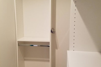 Diseño de armario vestidor unisex tradicional pequeño con armarios abiertos, puertas de armario blancas, moqueta y suelo marrón