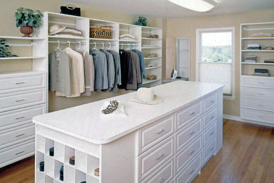 Example of a large transitional gender-neutral medium tone wood floor and brown floor dressing room design in Orange County with raised-panel cabinets and white cabinets