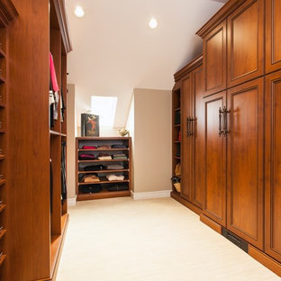 Diseño de armario vestidor unisex, tradicional, grande, con armarios estilo shaker, puertas de armario de madera en tonos medios, suelo de baldosas de porcelana y suelo beige
