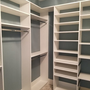 Imagen de armario vestidor unisex, clásico renovado, de tamaño medio, con armarios abiertos, puertas de armario blancas, suelo de baldosas de porcelana y suelo marrón