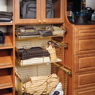 Foto di una cabina armadio per uomo chic di medie dimensioni con ante con bugna sagomata, ante in legno bruno e moquette