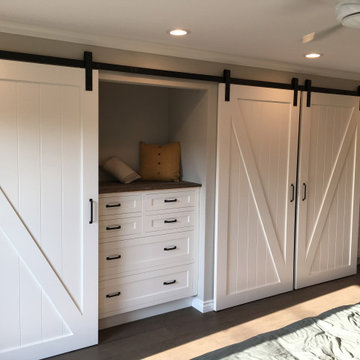 Custom handcrafted barn doors in custom closet with matching storage dresser