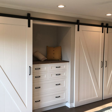 Custom handcrafted barn doors in custom closet with matching storage dresser