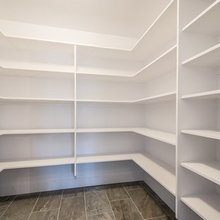 Cette photo montre un dressing tendance de taille moyenne et neutre avec un placard sans porte, des portes de placard blanches, un sol en carrelage de porcelaine et un sol gris.
