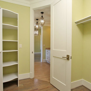 Idee per una cabina armadio unisex classica di medie dimensioni con ante con riquadro incassato, ante bianche, pavimento in legno massello medio e pavimento marrone
