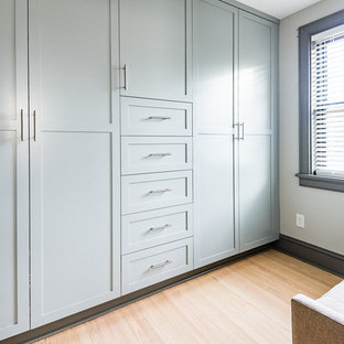 Idee per un armadio o armadio a muro moderno di medie dimensioni con ante in stile shaker, ante blu, parquet chiaro e pavimento marrone