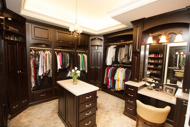 Example of a large tuscan gender-neutral carpeted dressing room design in Detroit with raised-panel cabinets and dark wood cabinets