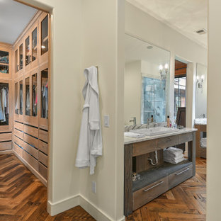 Diseño de armario y vestidor unisex, de estilo de casa de campo, grande, con armarios tipo vitrina, puertas de armario de madera clara y suelo de madera en tonos medios